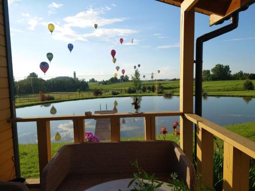 a view of hot air balloons flying over a lake at MĖTA in Birštonas