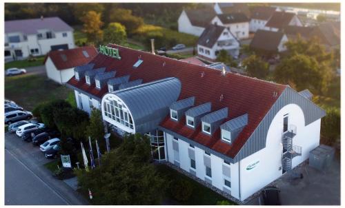 a large white house with a red roof and a parking lot at Hotel SunParc - SHUTTLE zum Europa-Park Rust 4km & Rulantica 2km in Ringsheim