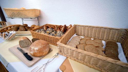a table with baskets of bread and loaves of bread at Hotel SunParc - SHUTTLE zum Europa-Park Rust 4km & Rulantica 2km in Ringsheim