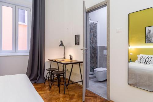 a bedroom with a mirror and a table and a bed at Brand new guest room with Wi-Fi in the city center in Trieste