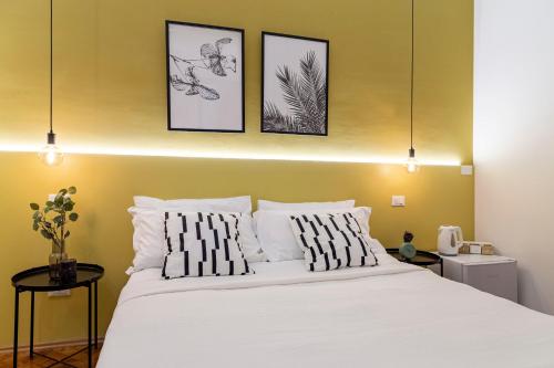a bedroom with a white bed with three pictures on the wall at Brand new guest room with Wi-Fi in the city center in Trieste