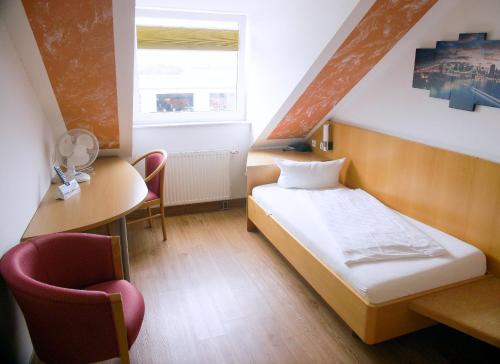 a small room with a bed and a table and chairs at Hotel SunParc - SHUTTLE zum Europa-Park Rust 4km & Rulantica 2km in Ringsheim