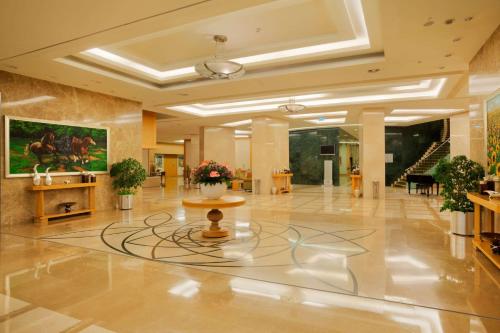 a lobby with a large lobby with a vase of flowers at Wyndham Grand İzmir Özdilek in Izmir