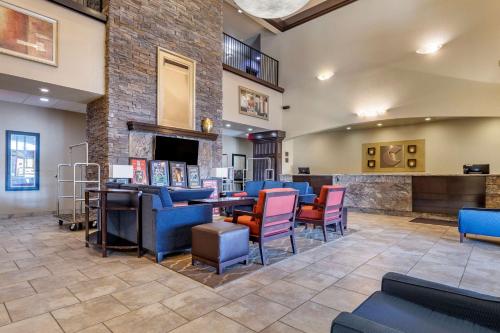 a lobby with blue and pink chairs and a bar at Comfort Inn Bentonville - Crystal Bridges in Bentonville