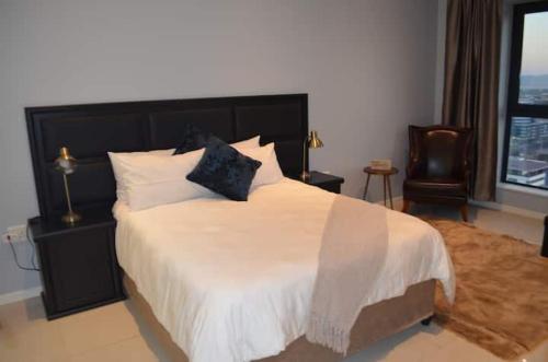 1 dormitorio con 1 cama grande y 1 silla en Casa Bonita, en Gaborone