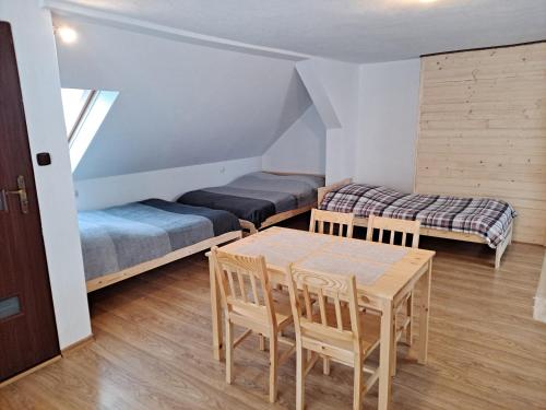 Zimmer mit einem Tisch, einem Bett und einem Sofa in der Unterkunft Agroturystyka pod kasztanem in Lutowiska