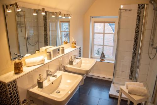łazienka z 2 umywalkami i prysznicem w obiekcie Hafenromantik Greetsiel w mieście Krummhörn
