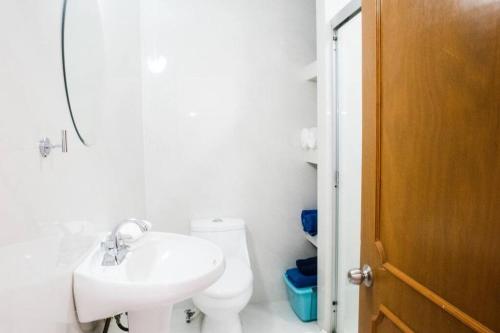 uma casa de banho branca com um lavatório e um WC em cancun marlin 32 em Cancún