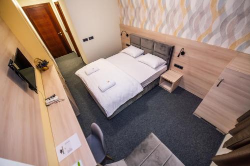 a small room with a bed and a chair at Zlatna Kruna in Banja Luka