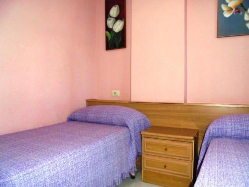 2 Betten in einem Zimmer mit lila Bettwäsche in der Unterkunft Europeñiscola Holidays LEK in Benicarló