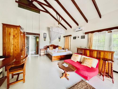 a bedroom with a bed and a desk at Villa Chez Batista in Takamaka