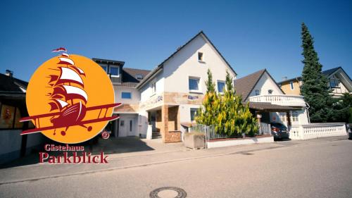 a sign for a restaurant on a street with a house at Gästehaus Parkblick in Rust