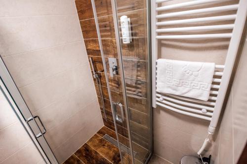 a shower stall with a white towel on a towel rack at Zlatna Kruna in Banja Luka