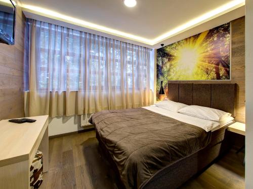 a bedroom with a large bed and a large window at Motel Bijele Vode in Mrakovica