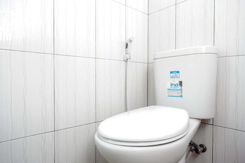 baño con azulejos blancos y aseo blanco en KoolKost Syariah near Malioboro Area, en Yogyakarta
