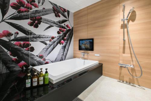 a bathroom with a shower and a white sink at HOTEL 粋 in Fukuyama