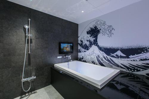 a bathroom with a large painting of a wave on the wall at HOTEL 粋 in Fukuyama