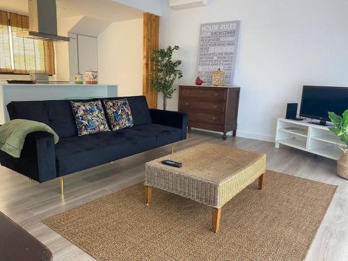 a living room with a blue couch and a coffee table at Seixal Old Town River View Apartment in Seixal