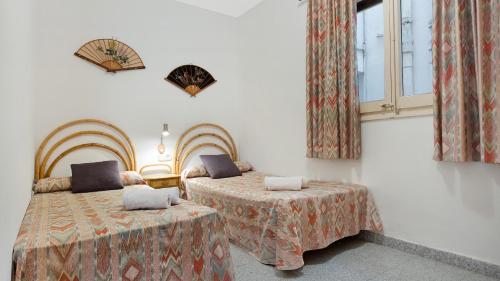 1 dormitorio con 2 camas y ventana en 1 Mars pl - Llafranc, en Llafranc