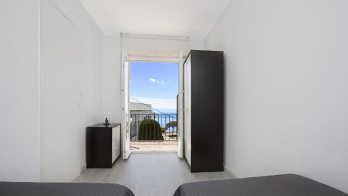 a bedroom with a door open to a balcony at 1 Mars 2 - Llafranc in Llafranc
