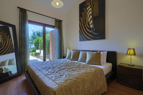 a bedroom with a bed and a large window at 3 bedroom Villa Madelini with private pool, Aphrodite Hills Resort in Kouklia
