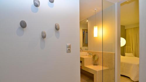 a bathroom with a shower and a sink and a mirror at Ino Hotel & Suites in Samos