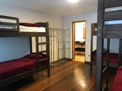 a room with three bunk beds and a hallway at Colonial Hostel in Sao Paulo