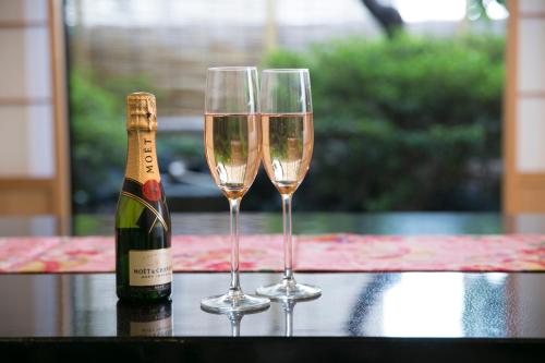 two champagne glasses sitting on a table with a bottle of champagne at Matsui Honkan in Kyoto