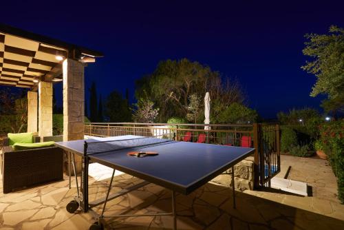 eine Tischtennisplatte auf einer Terrasse in der Nacht in der Unterkunft 3 bedroom Villa Madelini with private pool, Aphrodite Hills Resort in Kouklia