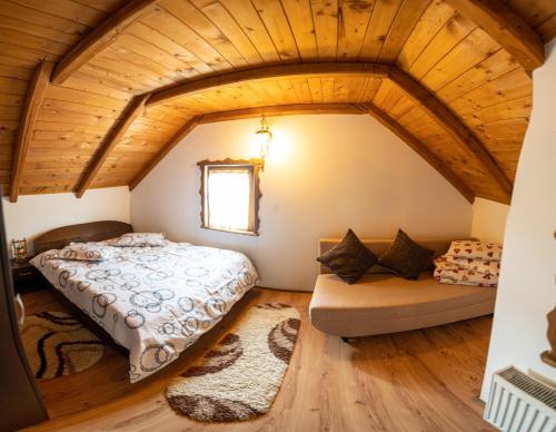 a bedroom with a large bed and a couch at Cabana Rustic in Borşa