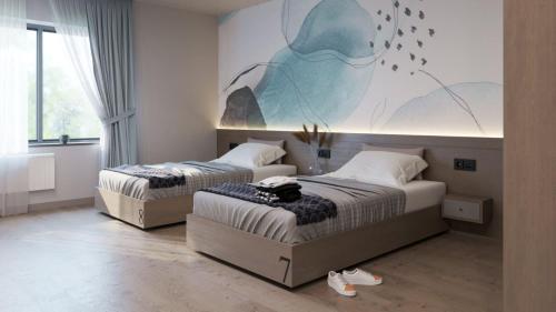 dwa łóżka w sypialni z malowidłem ściennym w obiekcie Garden plaza w mieście Neresnytsya