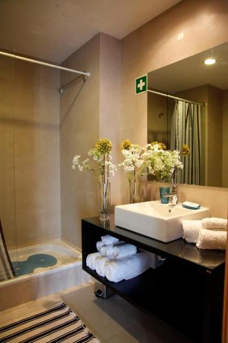 a bathroom with a sink and a mirror and a tub at ROCHA Tower 4D in Portimão