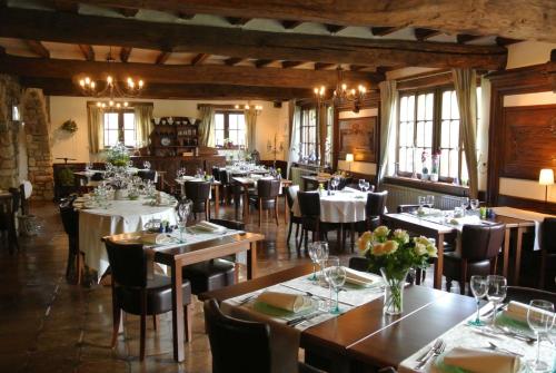 Hostellerie des Tilleuls في Smuid: مطعم فيه طاولات وكراسي في الغرفة