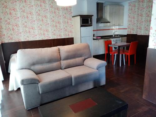 a living room with a couch and a kitchen at Apartamentos Astilleros in Candás