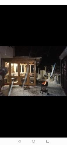 a living room with a table and a fireplace at Къща Томови,стаи за гости in Devin