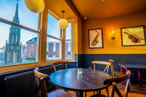 a dining room with a table and chairs and a large window at The Crown Hotel in Glastonbury