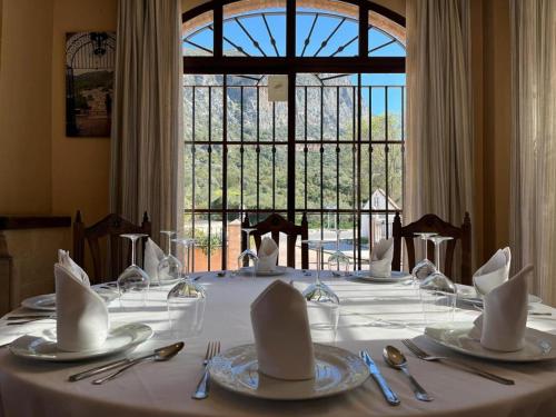 una mesa con platos y servilletas encima en Hotel Sierra de Ubrique, en Ubrique