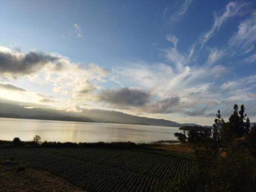 a view of a large body of water with a cloudy sky at Cabañas Villas Del Lago in Cuítiva
