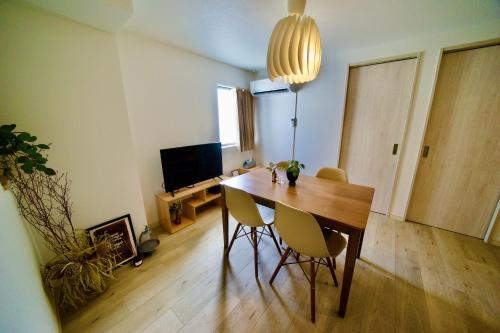 a dining room with a wooden table and chairs at 自由自在OSU 201(HANA) in Nagoya