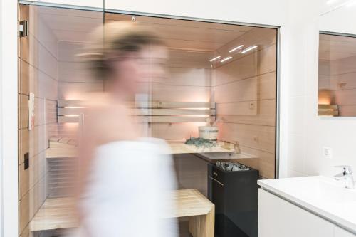 a person is walking through a bathroom with a sink at De Groote Duynen in Kamperland