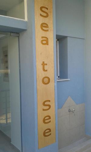 a sign on the side of a building that sayschange at Sea to See in Néa Péramos
