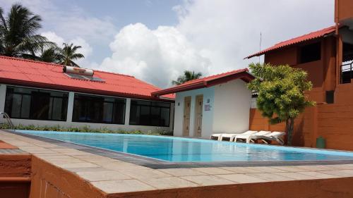 a swimming pool in front of a building at Ranga Holiday Resort in Bentota