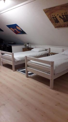 two white beds in a room with a ceiling at Royale bovenwoning in Vlake