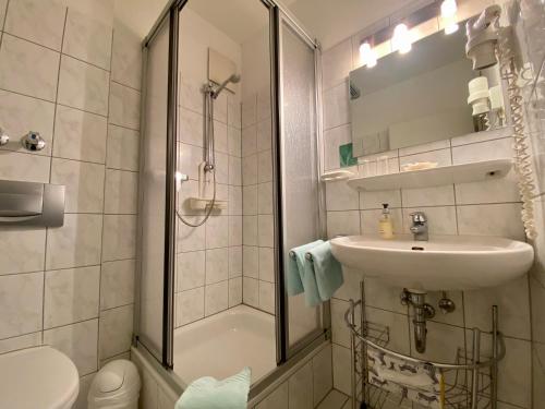 uma casa de banho com um chuveiro, um lavatório e um WC. em Hotel Kaiserswerth em Dusseldorf