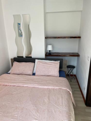 1 dormitorio con 1 cama grande con almohadas rosas en Casa Al Fiume Rio Seco, en Moghegno