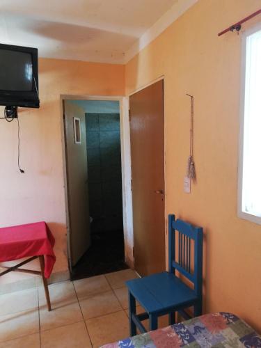 ein Zimmer mit einer Tür, einem Stuhl und einem Fernseher in der Unterkunft Casa particular Flavio in Salta