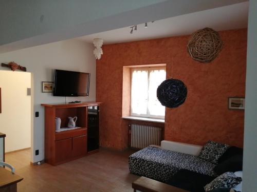 ein Wohnzimmer mit einem Sofa und einem TV in der Unterkunft Casa Nicole in Bardolino