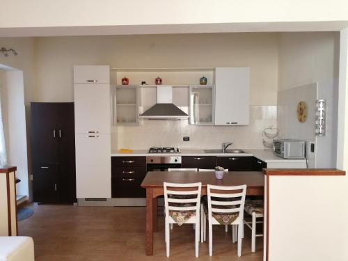 eine Küche mit einem Holztisch und eine Küche mit weißen Schränken in der Unterkunft Casa Nicole in Bardolino