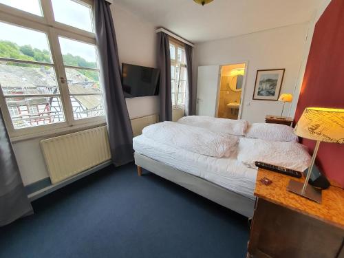 a bedroom with a bed and a large window at Haus Stehlings in Monschau
