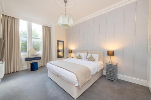 Un dormitorio con una cama grande y una lámpara de araña. en 20 Hertford Street, en Londres